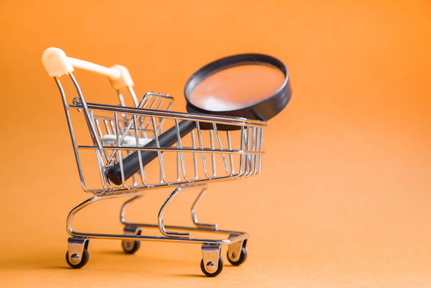 Online Shopping and Search. Trolley basket from the supermarket on an orange background. home delivery - Zdjęcie, obraz
