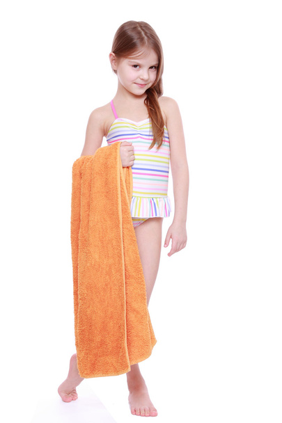 Little girl in swimsuit holding towel - Photo, image