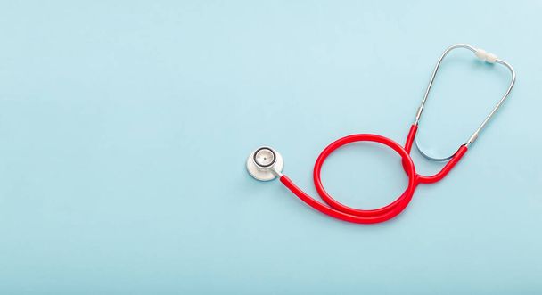Red stethoscope on blue color background. Concept of medicine and health care Pulmonology Cardiology . Top view copy space for text. Long web banner - Fotografie, Obrázek