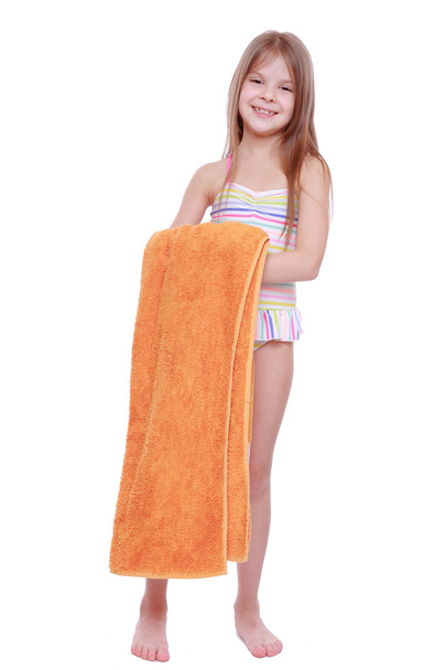 Little girl in swimsuit holding towel - Fotó, kép