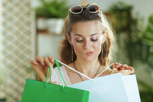 doubting modern woman shopper in sunglasses with paper shopping bags. - Foto, Imagem