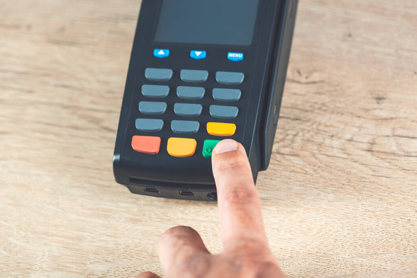 man hand payment terminal on the desk - Photo, Image