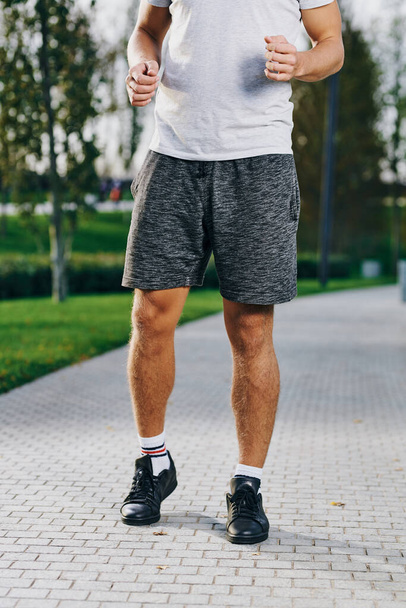 homem de esportes em shorts tênis e uma camiseta correndo no parque ao ar livre aptidão - Foto, Imagem
