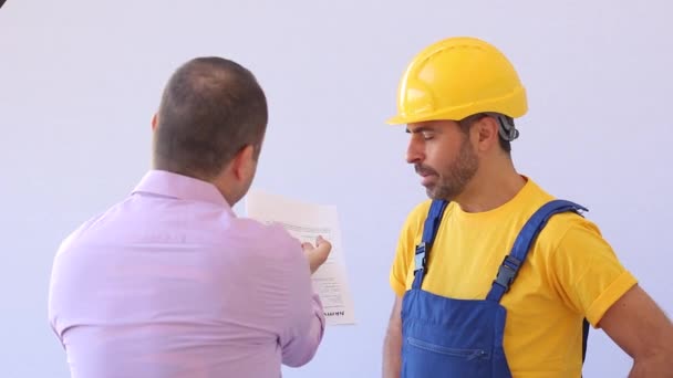 Builder with worker cloths stand on a ladder - Séquence, vidéo