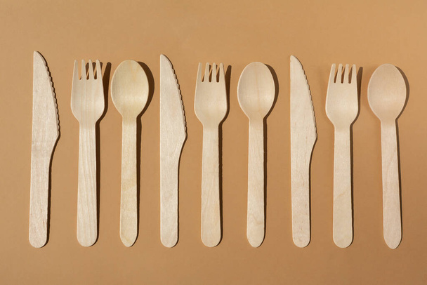 Contrast lighting. Flat lay. Eco friendly wooden cutlery. Fork and knife, spoon. Plastic Free Concept. - Zdjęcie, obraz