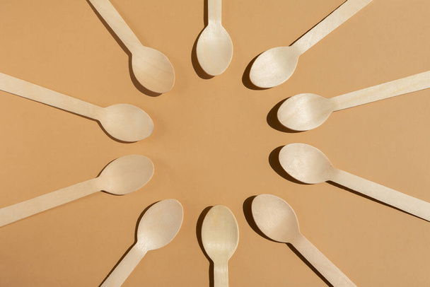 wooden spoons are laid out in a circle. Contrast lighting. Flat lay. Eco friendly wooden cutlery. Plastic Free Concept. - Fotó, kép