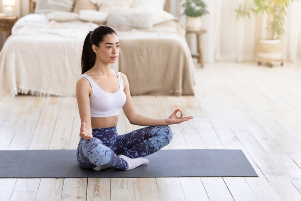 Harmonie de Yoga. Femme Asiatique Calme Méditant À La Maison, Assis En Position Lotus - Photo, image