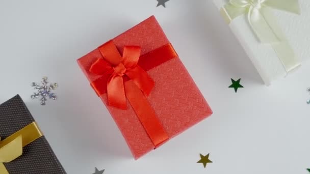 Χριστουγεννιάτικο φόντο. Τρία κουτιά: λευκό, κόκκινο. καφέ. Πρωτοχρονιά και Χριστούγεννα. Δώρο σε πρωτοχρονιάτικο φόντο. Νιφάδες χιονιού - Πλάνα, βίντεο