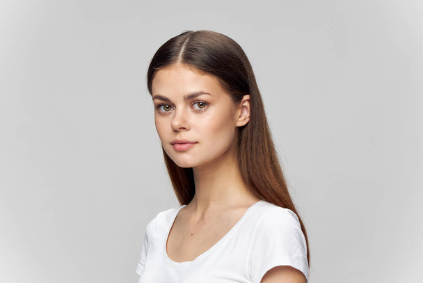 Woman portrait on a light background in a t-shirt beautiful face brunette Copy space - Fotó, kép