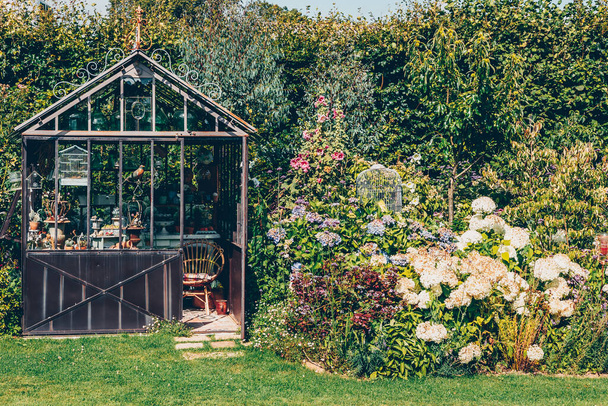 Decorative greenhouse in landscaped garden in summer - Photo, Image