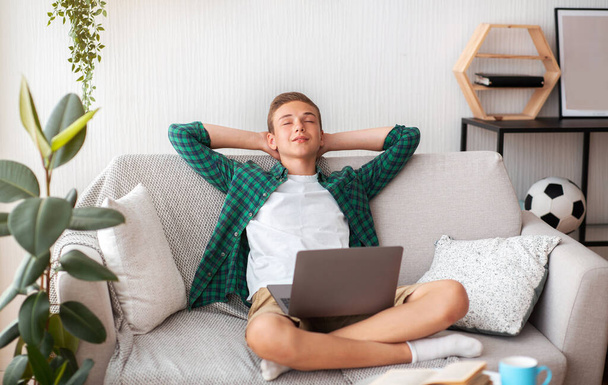 Adolescente alegre teniendo un descanso mientras estudia en casa - Foto, imagen