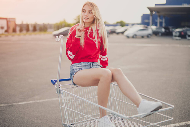Stylish woman riding shopping cart - Fotografie, Obrázek