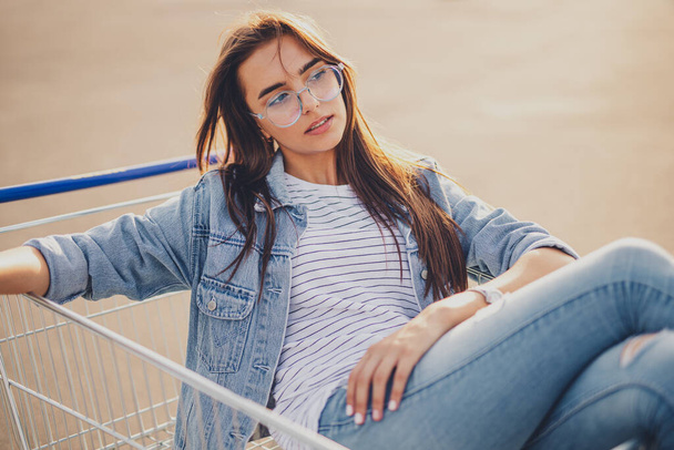 Young female resting in shopping cart - Фото, зображення