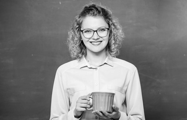 Energy charge for whole day. Dose of caffeine. Teacher in glasses drink coffee chalkboard background. Teaching is greatest act of optimism. Woman enjoy coffee before school classes. Coffee addicted - Foto, Imagen
