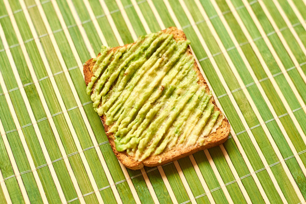 Toast with avocado on a green background. - Φωτογραφία, εικόνα