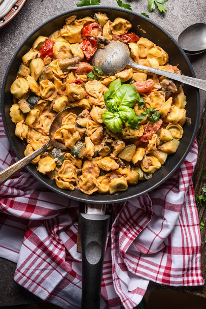 Vegetarian tortellini pot with vegetables sauce and spoons , top view, close up. Healthy cooking and eating. Italian food concept - Φωτογραφία, εικόνα