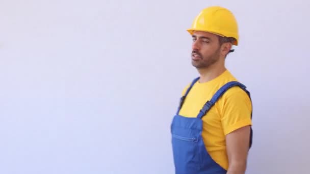 Builder with worker cloths stand on a ladder - Materiał filmowy, wideo