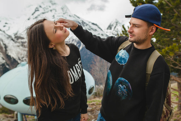 young hipster couple in love walking in mountains, swag outfit, winter vacation, romance, trendy style, having fun, jeans, backpack - Photo, image