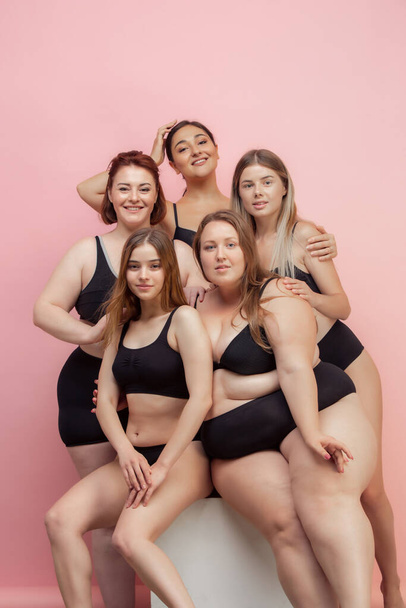 Portrait of beautiful young women with different shapes posing on pink background - Valokuva, kuva
