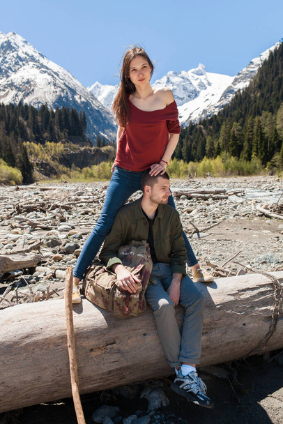 young hipster beautiful couple hiking at river in forest, jeans, sneakers, smiling, having fun, traveling, romantic vacation, mountains background - Foto, Bild