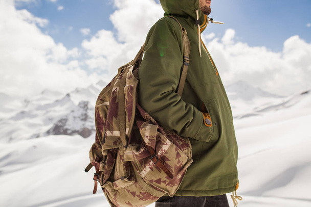 young hipster man hiking in mountains, winter vacation traveling, north, snow, warm clothes, backpack, anorak, close up, details - Foto, afbeelding