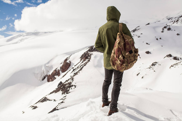 young hipster man hiking in mountains, winter vacation traveling, north, snow, warm clothes, backpack, anorak - Foto, afbeelding