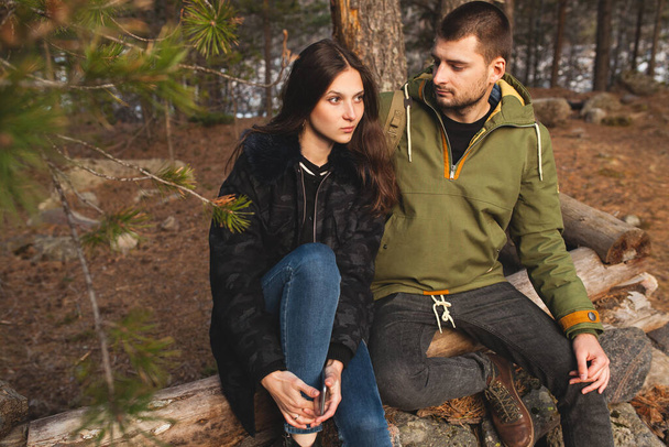 young beautiful hipster man and woman in love traveling together in wild nature, hiking in forest, autumn style apparel, coat, romance, vacation, warm clothes - Foto, Imagem