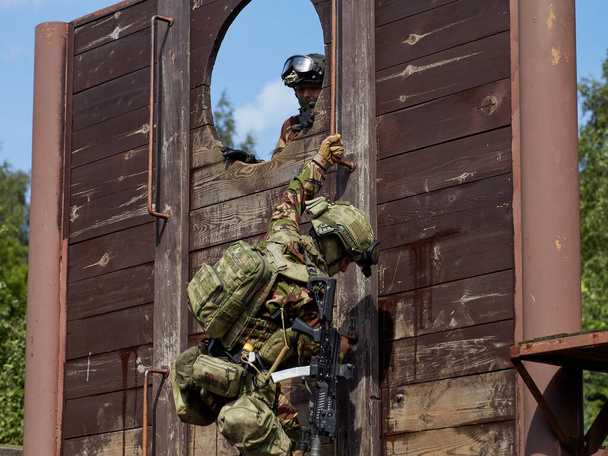 Żołnierze sił specjalnych szturmują mury. - Zdjęcie, obraz