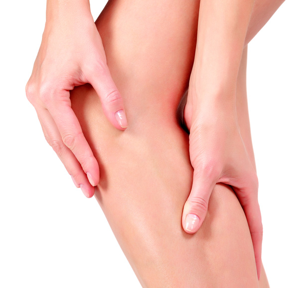 Woman holding sore knee, on white background - Foto, imagen