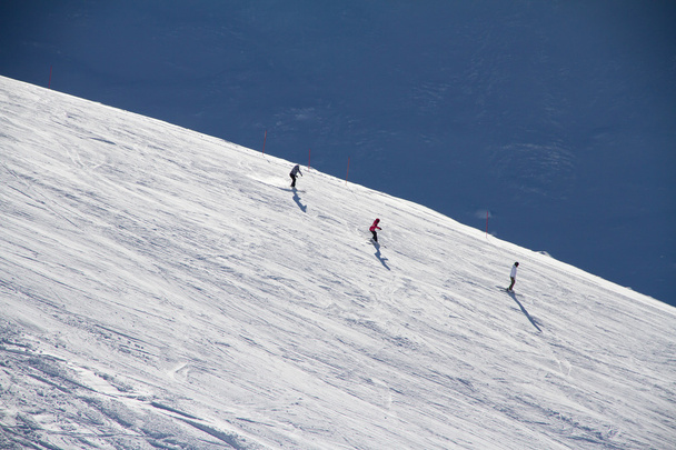 Skiers going down the slope at ski resort. - Zdjęcie, obraz