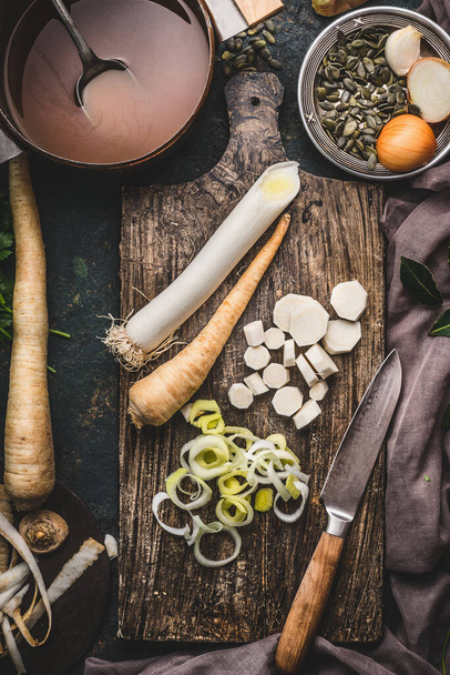 Food background with fresh parsnips roots on dark kitchen tables with knife. Top view. Vegetables cooking concept - Fotografie, Obrázek