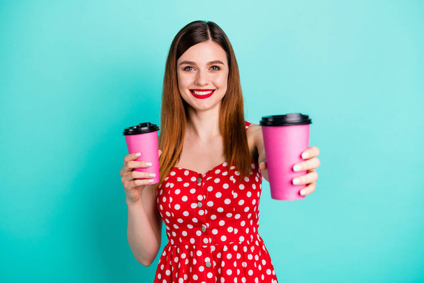 Here your latte. Portrait of positive cheerful girl buy takeout coffee cup hold give her friend wear dotted skirt sundress isolated over teal color background - Foto, imagen