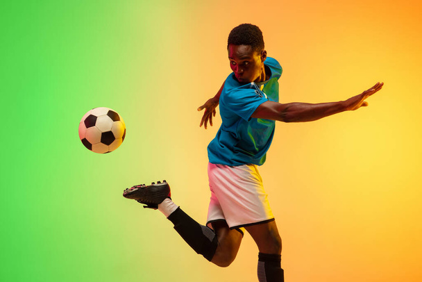 Erkek futbol, hareket halinde futbol antrenmanı neon ışıklı arka planda izole edilmiş. - Fotoğraf, Görsel