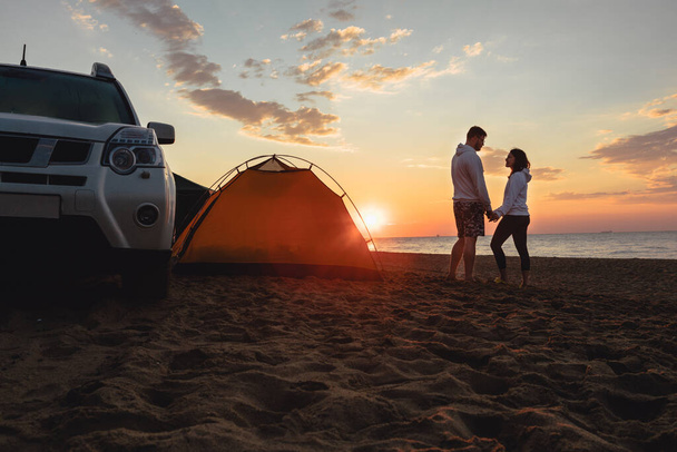 couple looking at sunrise. camping lifestyle. suv off road. yellow tent - Photo, Image