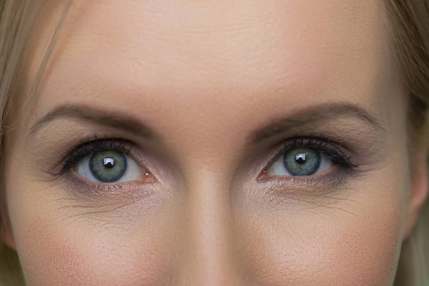 Κοντινό γυναικείο πρόσωπο με όμορφα μπλε μάτια. - Φωτογραφία, εικόνα