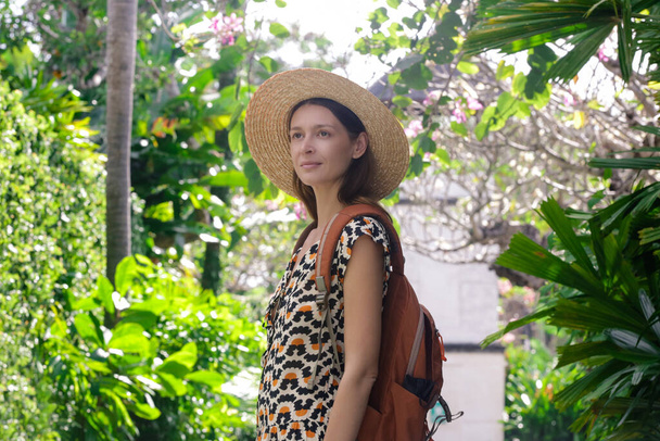 Donna turistica con cappello di paglia e zaino arancione durante le vacanze estive. - Foto, immagini