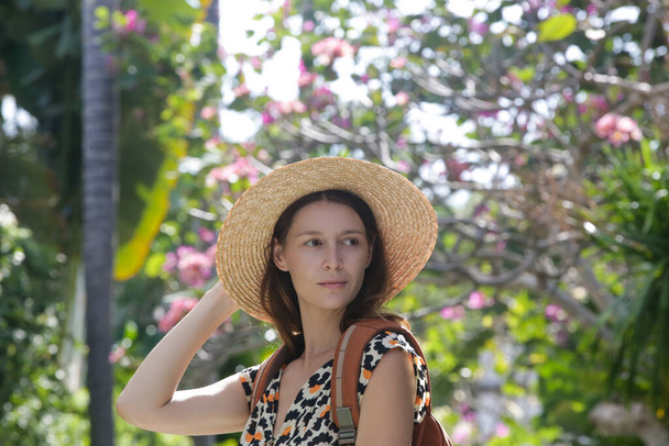 Turistka nosí slamák a oranžový batoh na své letní dovolené. - Fotografie, Obrázek