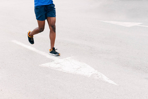 unrecognizable man running on the asphalt - Фото, изображение