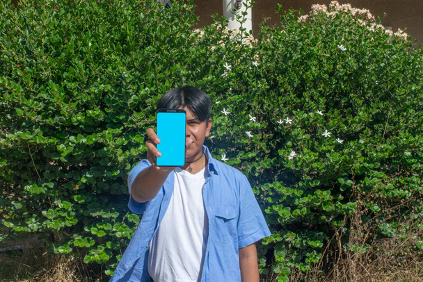 Latin student showing his cell phone - Photo, Image