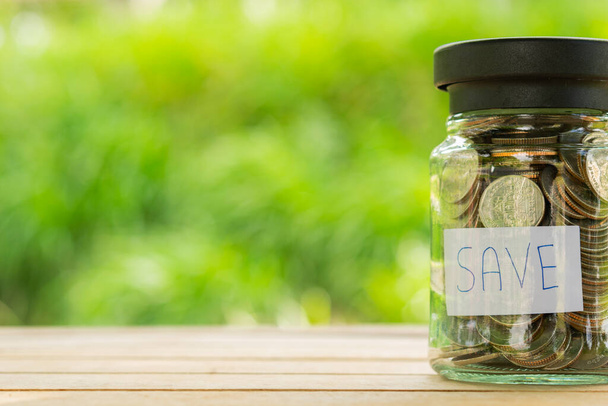 Money in the glass bottle for saving with nuture green bokeh background. Saving money, Saving concept - Foto, immagini