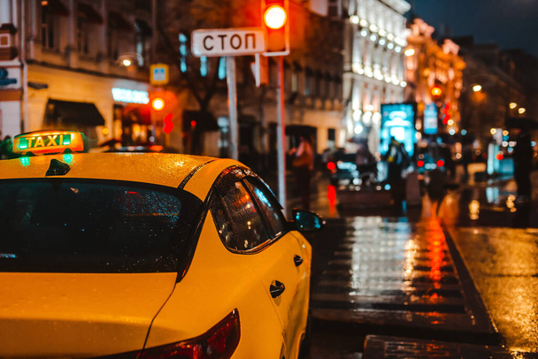 Nedves éjszaka városi utcai eső Bokeh tükröződés fényes színes fények pocsolyák járda Autó fényszórók világítás tükröződés nedves aszfalt út. forgalmi torlódások, csúcsforgalom, taxi, közlekedés, sárga - Fotó, kép