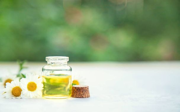 Chamomile essential oil in a small bottle. Selective focus. nature. - Foto, Bild