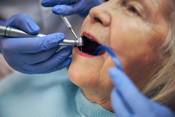 Dentiste et assistant traitant le patient équipements modernes - Photo, image