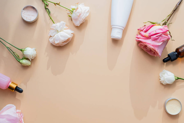 Cosmetics from natural ingredients and extracts of flowers and roses on a beige background. Cream, lotion, gel in white tubes with mock up. - Fotó, kép