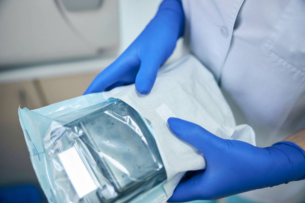 Orvosi műszerek kék kesztyűben a kezükben - Fotó, kép