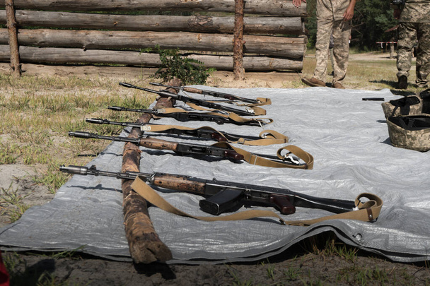 AK-74 subfusiles se encuentran en una fila en lugares de entrenamiento. - Foto, Imagen