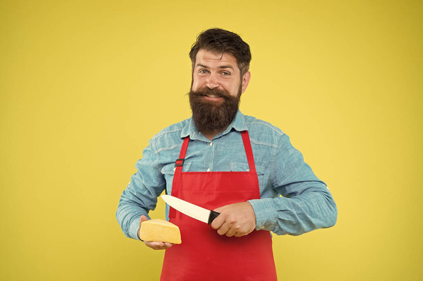 Gourmet product. Dairy product derived from milk. Online shopping. Diet and nutrition. Salesman concept. Cheese maker. Bearded man in apron hold piece cheese. Shop staff occupation. Buy cheese - Zdjęcie, obraz