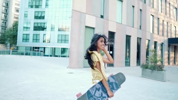 chica bastante atlética monta un longboard en la ciudad moderna - Metraje, vídeo