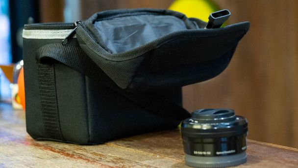 Объектив камеры рядом с сумкой держателя камеры - Фото, изображение