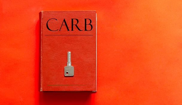 κόκκινο βιβλίο με Carb κείμενο και ένα κλειδί σε ένα κόκκινο φόντο - Φωτογραφία, εικόνα